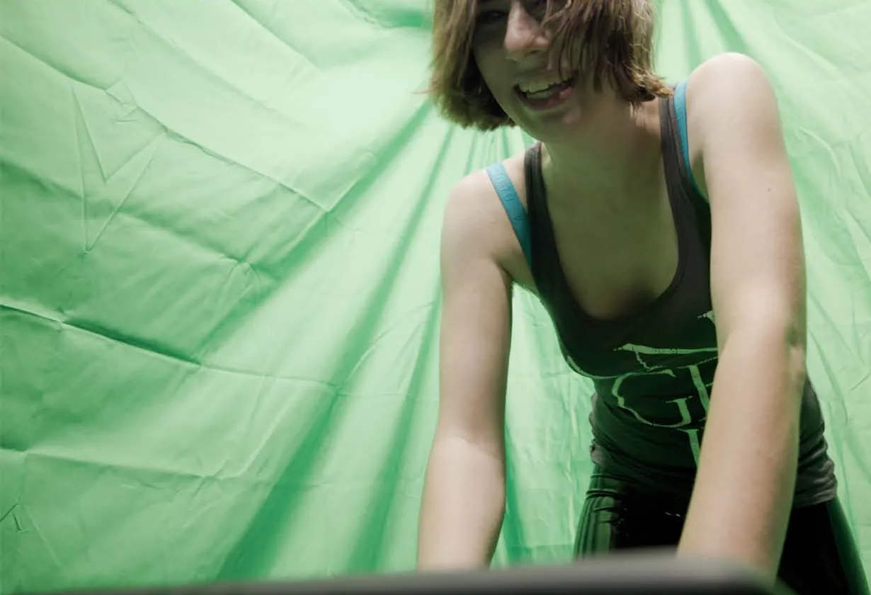 Kady at a keyboard in front of a green screen.
